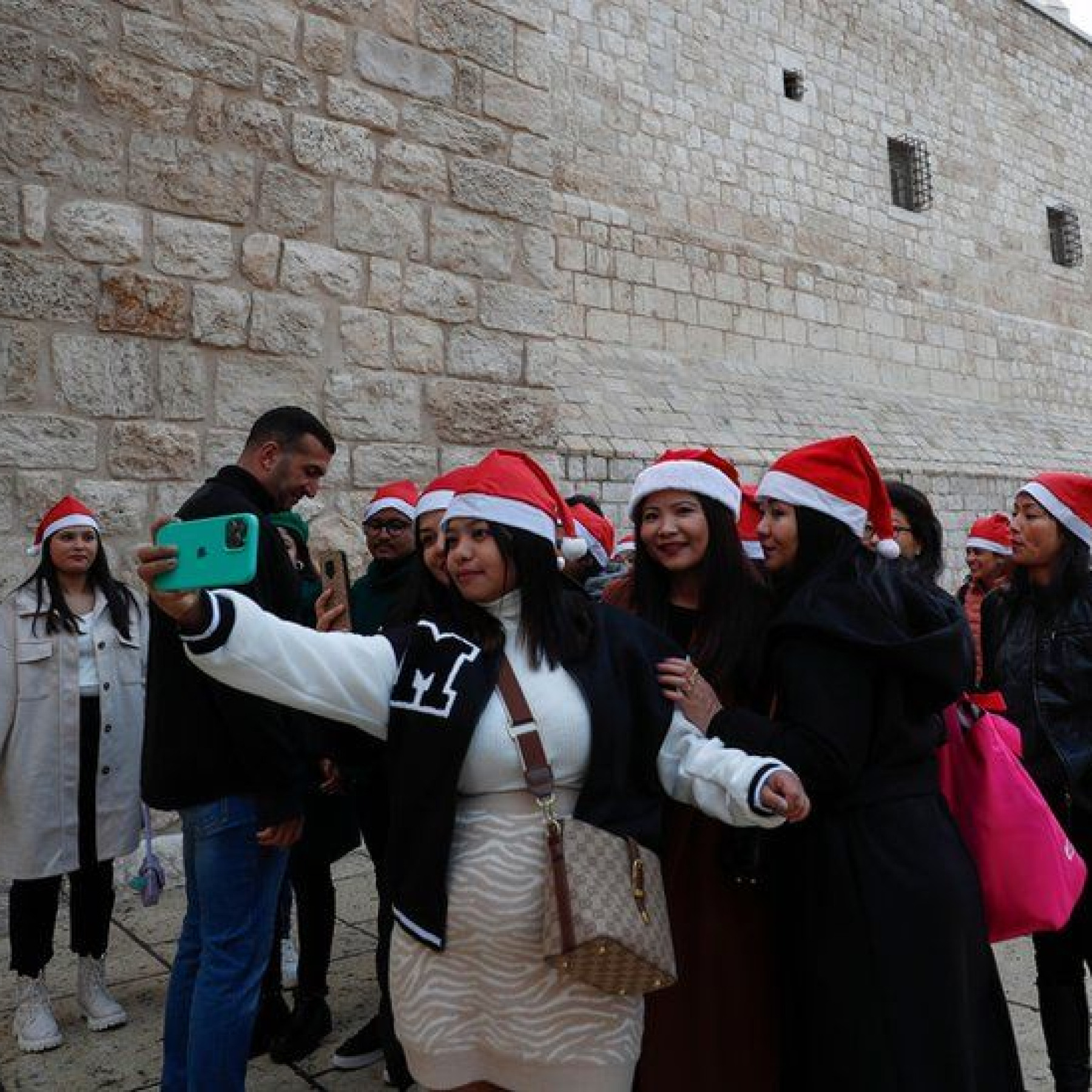 Tourists heading for the Church of Nativity in Bethlehem gather for a selfie