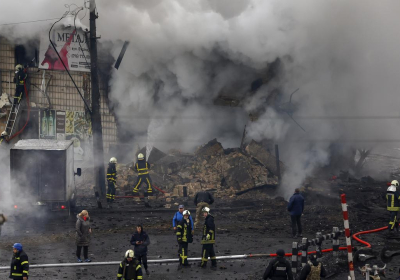Fire and rescue workers attend a building hit by a missile in central Kyiv